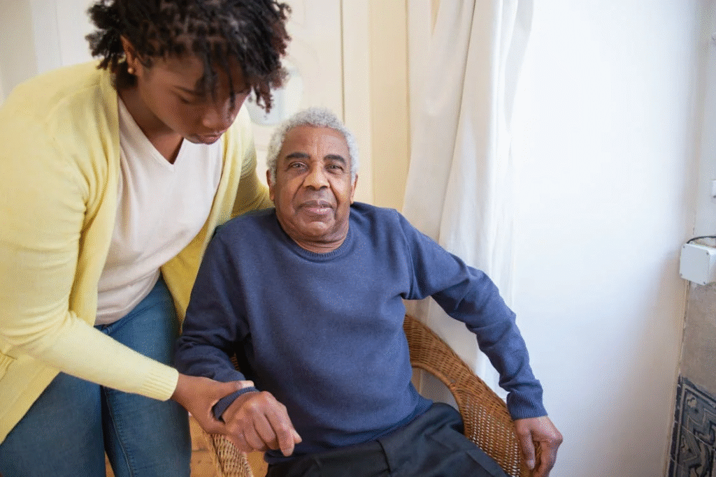 Caregiver assisting an elderly man at home, symbolizing the need for 24-hour in-home care.