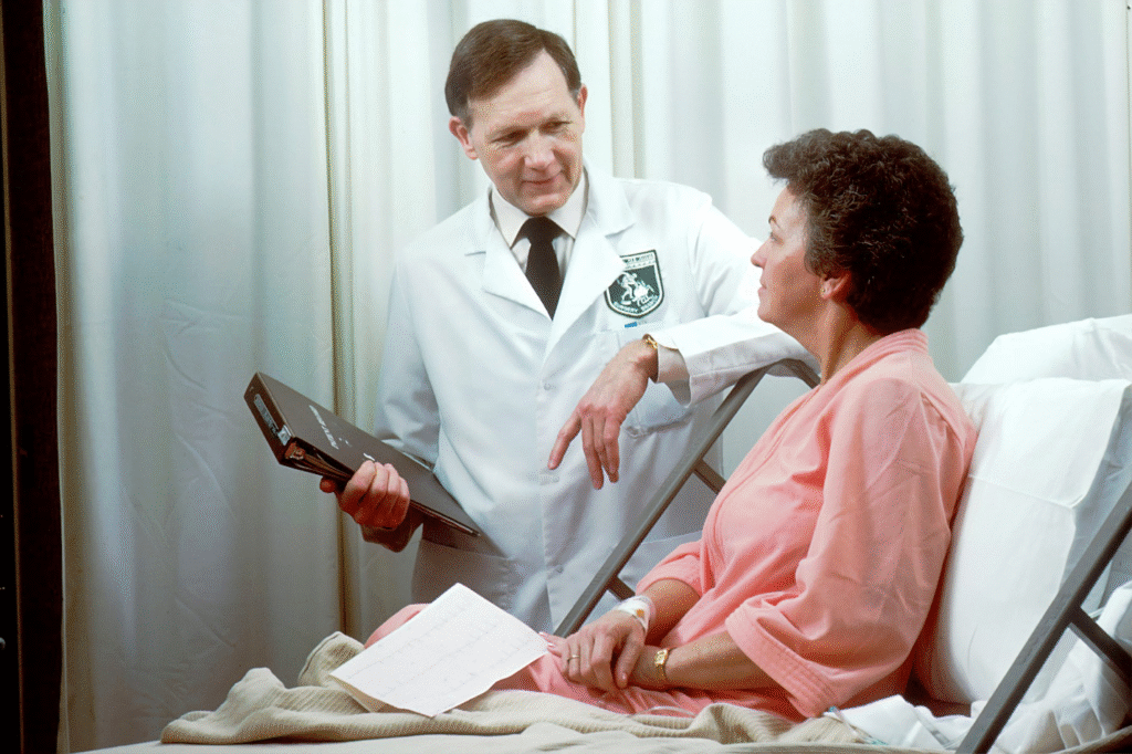 A person sitting on a bed being helped by a professional doctor.