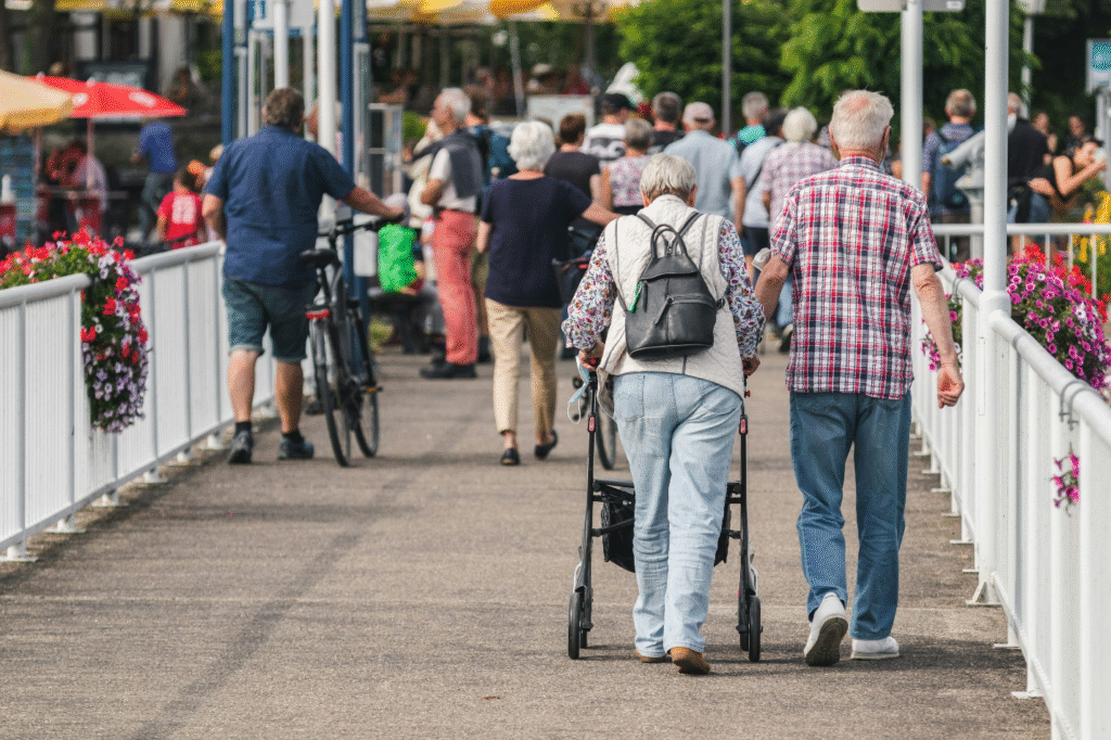 Two older people walking together on a bridge