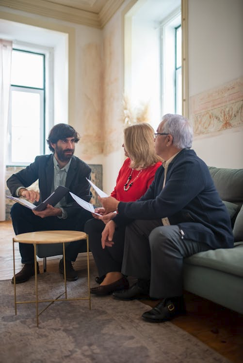Adult children sitting with elderly parents discussing care options
