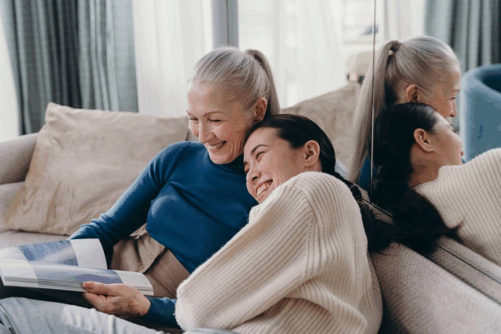 an elderly woman laughing with her caregiver at home