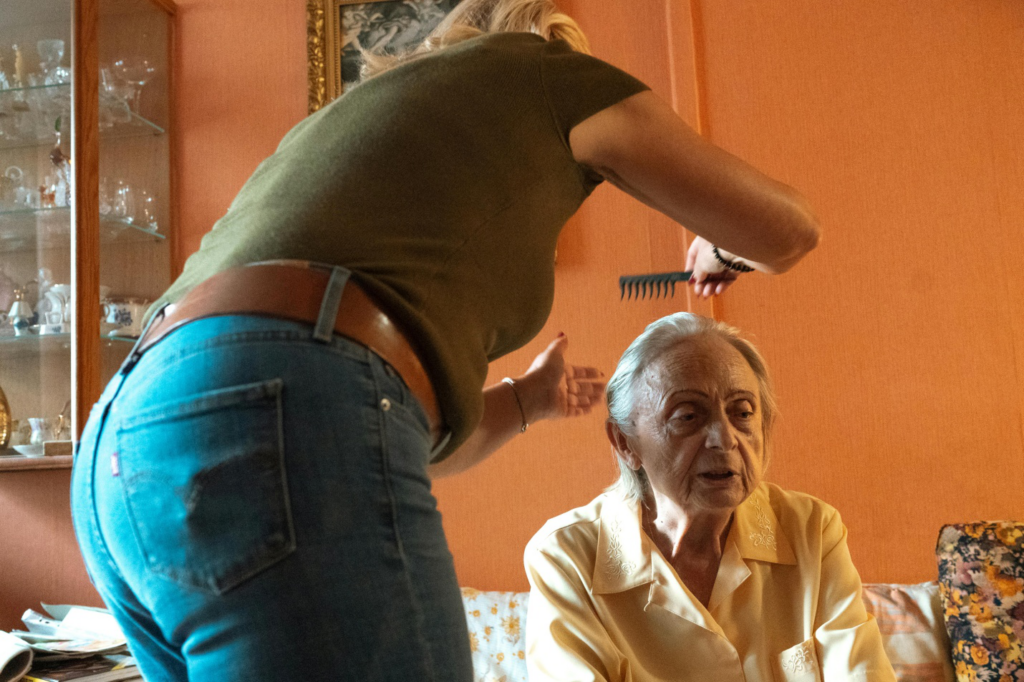A caregiver combing a senior woman's hair