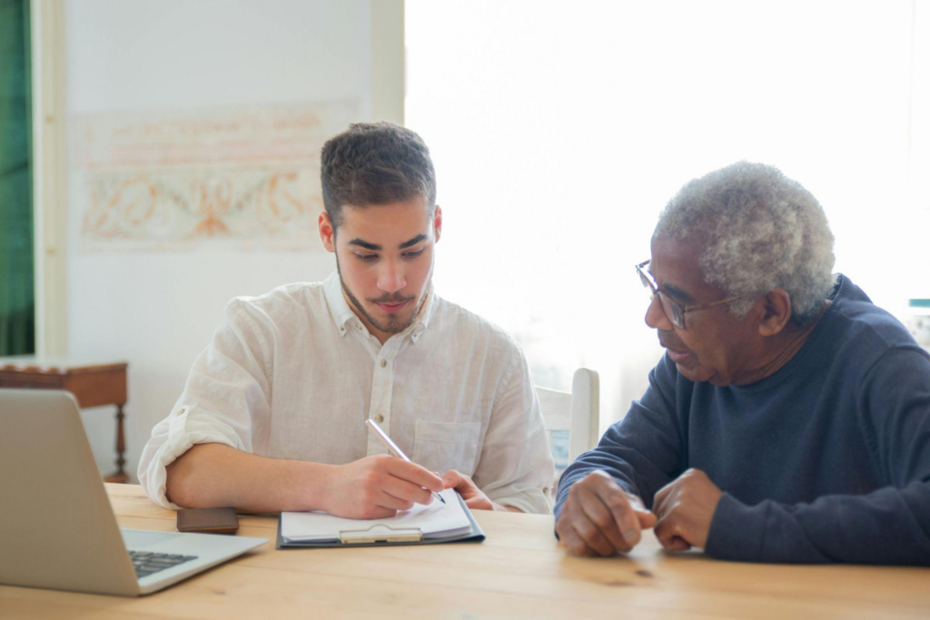 an aide sitting with an elderly man