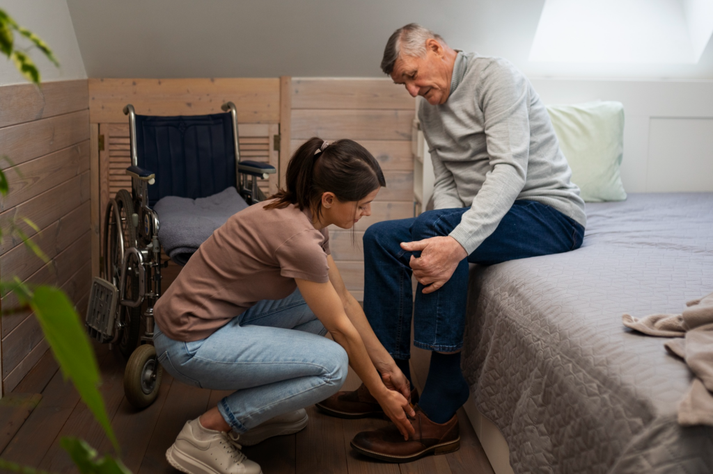 A caregiver helping an elderly person wear shoes