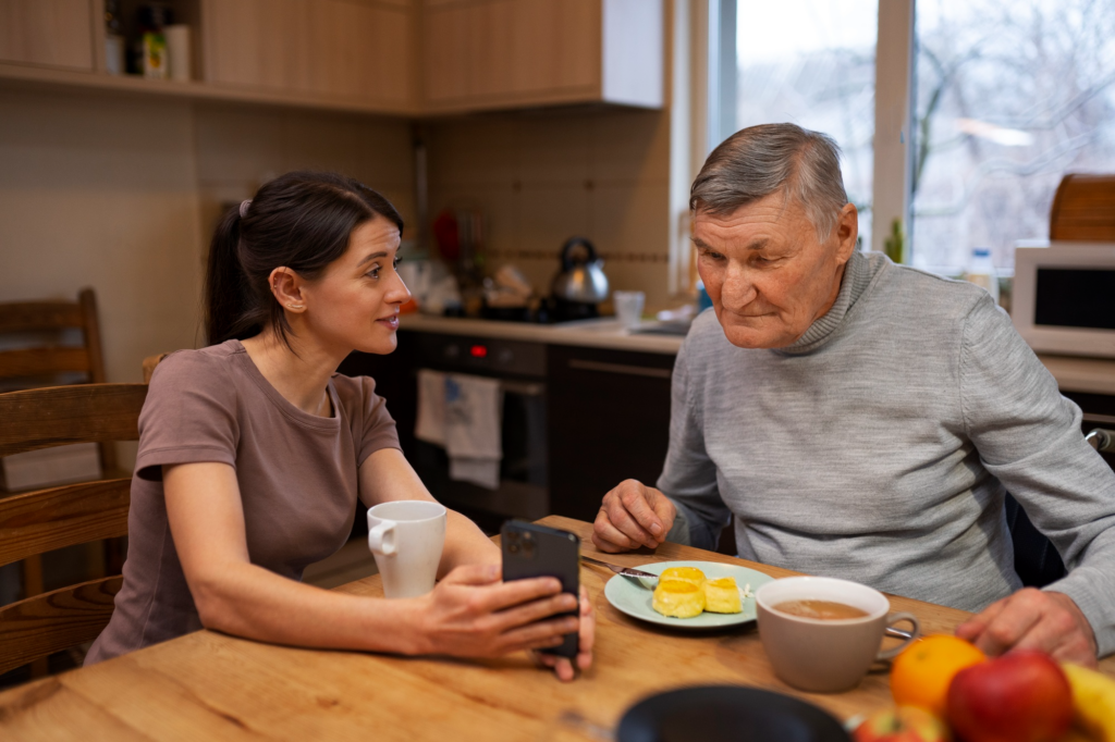 A caregiver showing a video on the phone to an elderly person