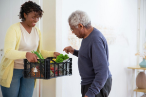 a caregiver carrying groceries for an elderly person