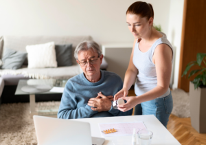 A caregiver showing medicines to an elderly man