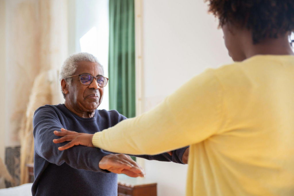 a caregiver helping an elderly person exercise