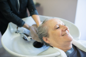 An elderly woman getting a hair wash