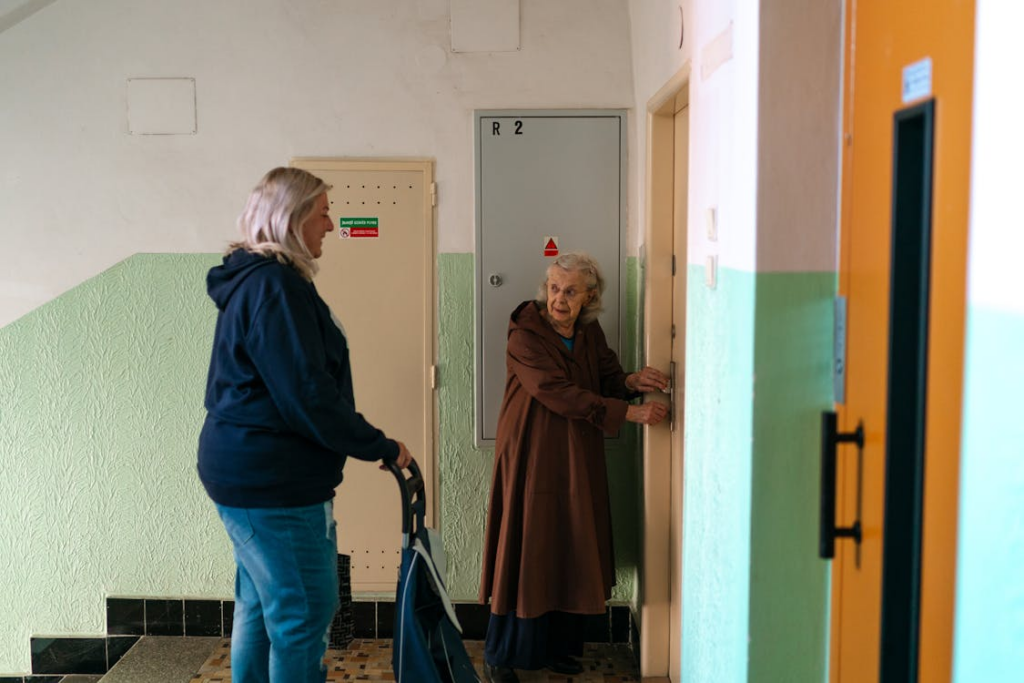A senior person and her caregiver in the hallway